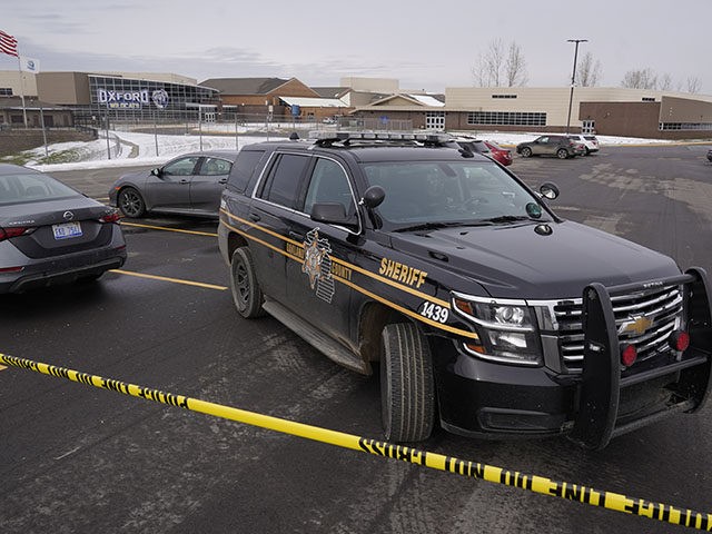 An Oakland County Sheriff's deputy guards the parking lot of Oxford High School in Oxford, Mich., Wednesday, Dec. 1, 2021. A 15-year-old sophomore opened fire at the school, killing several students and wounding multiple other people, including a teacher. (AP Photo/Paul Sancya)