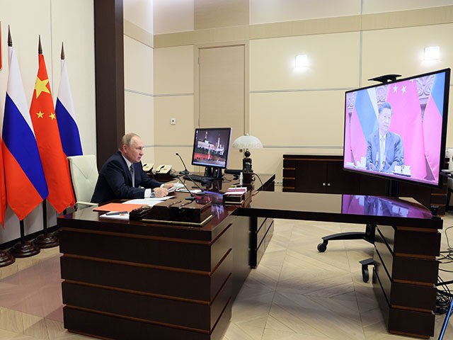 Russian President Vladimir Putin speaks with Chinese President Xi Jinping, right on the sc
