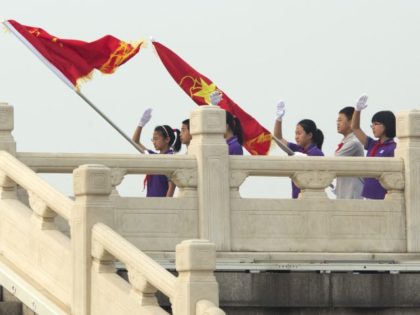 Chinese students perform a ceremonial post guarding of Young Pioneers, a youth group under the Chinese Communist Party, on Tiananmen Square in Beijing, Friday, May 1, 2015. Millions of Chinese are taking advantage of the May Day holidays to visit popular tourist sites.