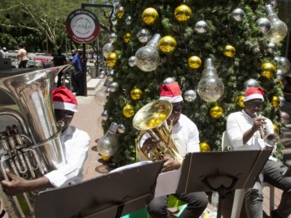 A small brass band plays Christmas carols for shoppers at a mall in Johannesburg, Friday, Dec. 24, 2021.