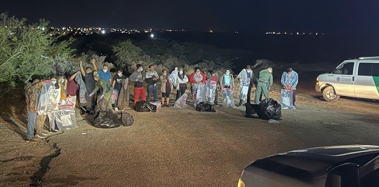 Agents search migrants and bag their property after human smugglers marched them into Roma, Texas, on Christmas Eve. (Randy Clark/Breitbart Texas)