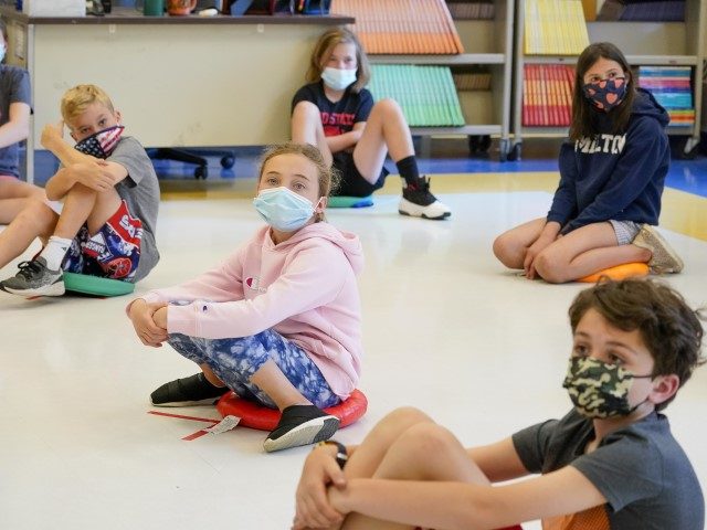 FILE - In this May 18, 2021 file photo, fifth graders wearing face masks are seated at proper social distancing spacing during a music class at the Milton Elementary School in Rye, N.Y. As more children go back to the physical classroom, families are expected to spend robustly on a …