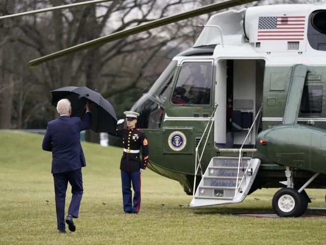 President Joe Biden closes his umbrella as he walks to board Marine One on the South Lawn of the White House in Washington, Monday, Dec. 27, 2021, en route to Rehoboth Beach, Del.
