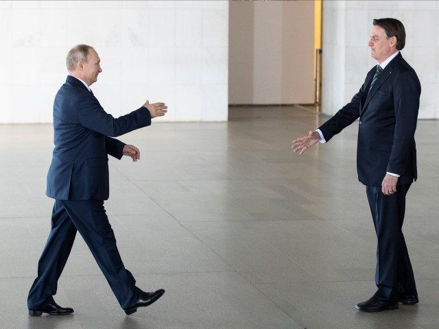 Brazil's President Jair Bolsonaro (R) welcomes Russia's President Vladimir Putin before the 11th BRICS Summit at the Itamaraty palace on November 14, 2019 in Brasilia, Brazil. - Brazil's President Jair Bolsonaro walked a diplomatic tightrope, as he seeks to boost ties with Beijing and avoid upsetting key ally Donald Trump, …