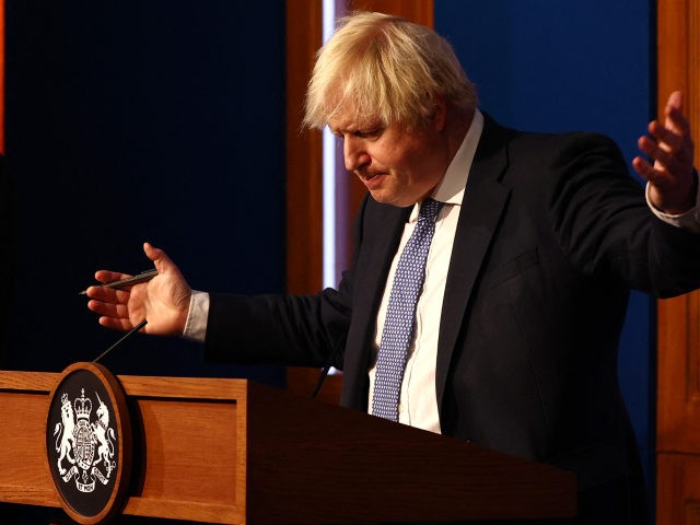 TOPSHOT - Britain's Prime Minister Boris Johnson gestures during a press conference for the latest Covid-19 update in the Downing Street briefing room in central London on December 8, 2021. - The UK government is reintroducing Covid-19 restrictions due to the Omicron variant. (Photo by Adrian DENNIS / POOL / …