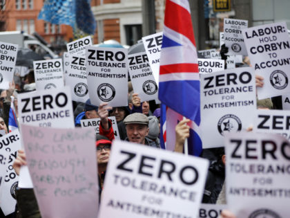 TOPSHOT - People hold up placards and Union flags as they gather for a demonstration organised by the Campaign Against Anti-Semitism outside the head office of the British opposition Labour Party in central London on April 8, 2018. - Labour leader Jeremy Corbyn has been under increasing pressure to address …