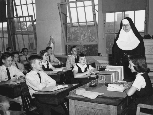 Catholic nun Sister Mary Zita looks on as class president Susan presides over a class meet