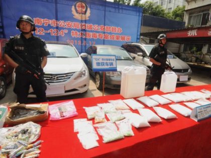 In this picture taken on May 17, 2012, Chinese police display nearly 50kg of seized illicit drugs and various drug-making equipment, along with the cars confiscated in three different raids on drug processing labs in Nanning, southwest China's Guangxi province. Fifteen suspects were also detained in the raids as authorities …