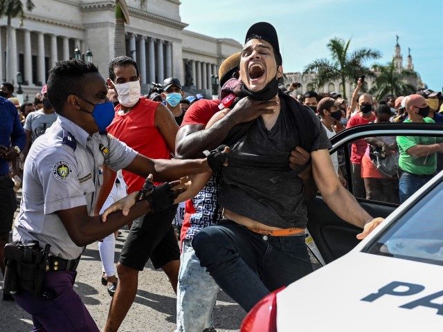 TOPSHOT - A man is arrested during a demonstration against the government of Cuban President Miguel Diaz-Canel in Havana, on July 11, 2021. Thousands of Cubans took part in rare protests Sunday against the communist government, marching through a town chanting "Down with the dictatorship" and "We want liberty."
