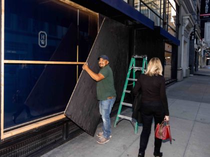 SAN FRANCISCO, CA - NOVEMBER 30: Raul Gomez removes wood paneling used to secure a store near Union Square on November 30, 2021 in San Francisco, California. Stores have increased security in response to a spike in thefts. (Photo by Ethan Swope/Getty Images)