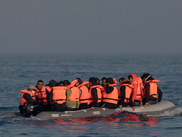 AT SEA, ENGLAND - JULY 22: An inflatable craft carrying migrant men, women and children cr