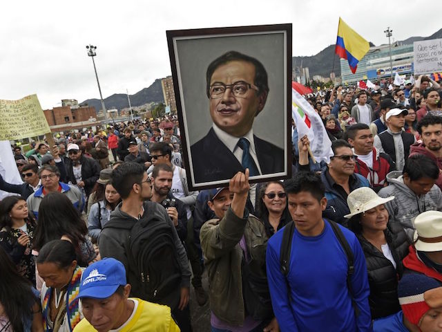 A man holds a picture of former presidential candidate Gustavo Petro as he demonstrates against Colombia's President-elect Ivan Duque on the day of his inauguration, in Bogota, on August 7, 2018. - Duque has his work cut out for him as he takes office Tuesday amid heightened tensions with neighbouring Venezuela and the lingering difficulties of peace-building with the nation's rebel groups. (Photo by JUAN BARRETO / AFP) (Photo credit should read JUAN BARRETO/AFP via Getty Images)