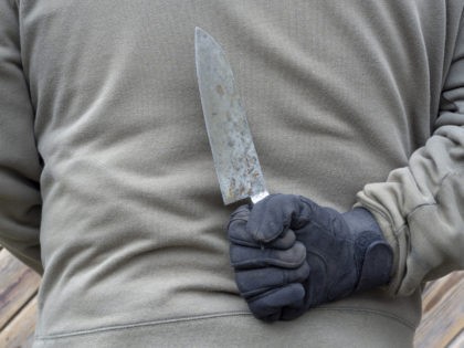 man wearing black glove and holding knife