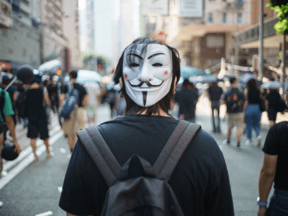 In this picture taken on October 1, 2019, a protester wears a Guy Fawkes mask on the back of his head, popularised by the V For Vendetta comic book film, in Hong Kong. - The face coverings have been embraced by multiple protest movements in recent years, particularly Anonymous hactivists …