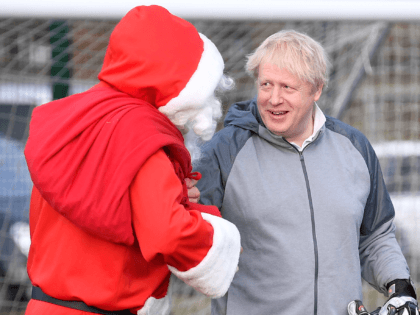 CHEADLE HULME, UNITED KINGDOM - DECEMBER 07: British Prime Minister Boris Johnson greets a man dressed as Father Christmas during the warm up before a girls' soccer match between Hazel Grove United JFC and Poynton Juniors on December 7, 2019 in Cheadle Hulme, United Kingdom. The Prime Minister is campaigning …