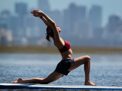 Yoga instructor Sarah Henry leads a class during a paddleboard yoga session at Adventure S