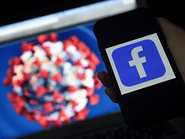 Facebook logo is displayed on a mobile phone screen photographed on coronavirus COVID-19 i