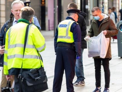 Irish police officers, or Garda officers, talk with members of the public as they conduct checks on pedestrians and motorists in Dublin city centre on April 8, 2020, as life in Ireland continues during the nationwide lockdown to combat the novel coronavirus pandemic. - Irish police set up nationwide traffic …