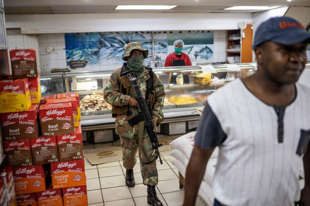 A South African National Defence Force (SANDF) soldier searches for people not wearing face masks in a supermarket in Hillbrow, Johannesburg, on May 1, 2020, during a joint patrol by the South African National Defence Force (SANDF), the South African Police Service (SAPS) and the Johannesburg Metro Police Department (JMPD). - South Africa began to gradually loosen its strict COVID-19 coronavirus lockdown on May 1, 2020, after five weeks of restrictions. Social distancing and wearing masks in public and at workplaces will be mandatory. (Photo by Michele Spatari / AFP) (Photo by MICHELE SPATARI/AFP via Getty Images)
