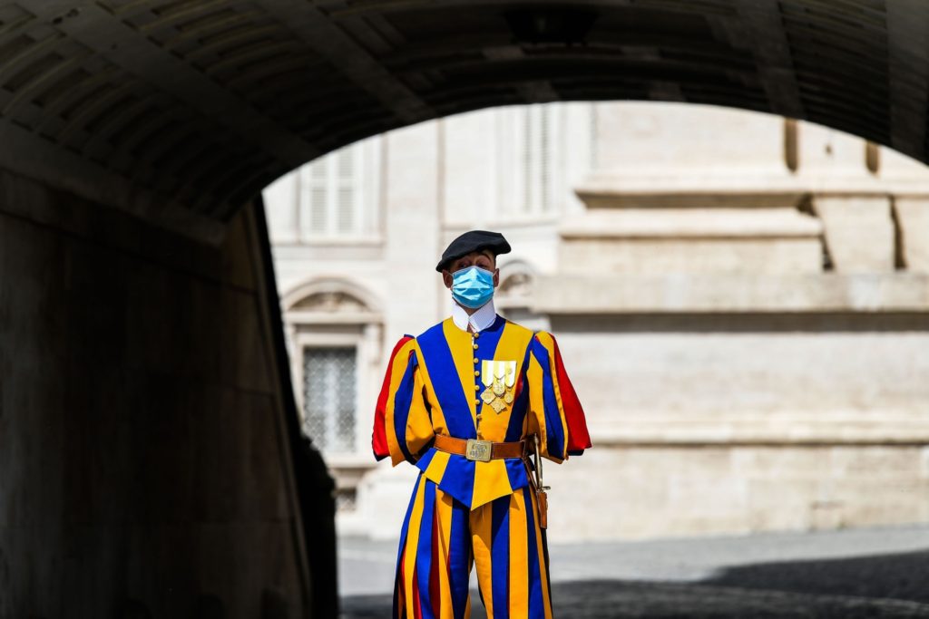 A Swiss Guard wearing a face mask stands guard by St. Peter's Basilica as it reopens on May 18, 2020 in The Vatican during the lockdown aimed at curbing the spread of the COVID-19 infection, caused by the novel coronavirus. - Saint Peter's Basilica throws its doors open to visitors on May 18, 2020, marking a relative return to normality at the Vatican and beyond in Italy, where most business activity is set to resume. (Photo by Vincenzo PINTO / AFP) (Photo by VINCENZO PINTO/AFP via Getty Images)
