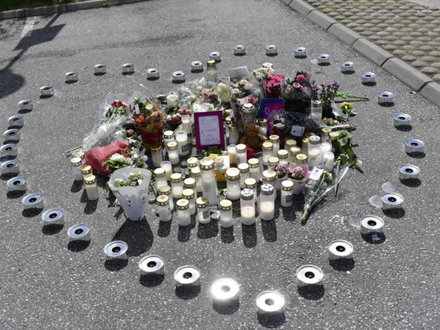 A makeshift memorial in form of a heart with candles and flowers is seen at the site where a twelve year old girl was shot near a petrol station in Botkyrka, south of Stockholm, on August 3, 2020. - The young girl suffered gunshot injuries on the early morning of …