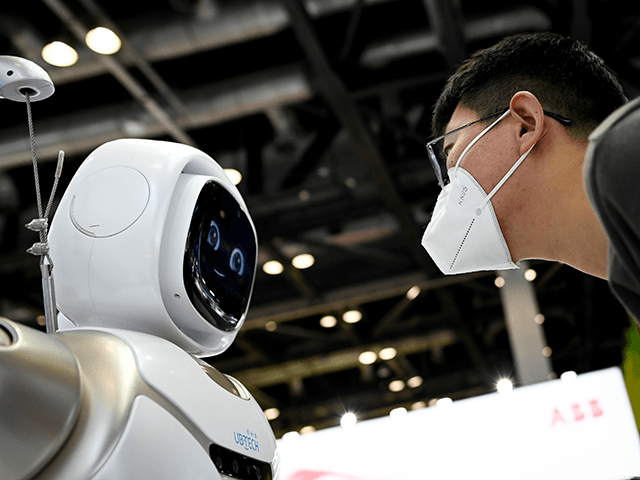 A man wearing face mask looks at a robot at the China National Convention Centre, the venue for the upcoming the China International Fair for Trade in Services (CIFTIS) in Beijing on September 3, 2020. (Photo by WANG Zhao / AFP) (Photo by WANG ZHAO/AFP via Getty Images)