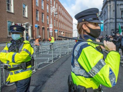 Garda stand with batons drawn to keep counter-protestors from protestors staging a demonstration against the Irish government imposed restrictions put in place to help stem the rise in the number of novel coronavirus COVID-19 cases, outside Leinster House in Dublin on October 10, 2020. - Ireland on Tuesday ratcheted up …