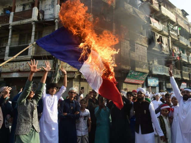 TOPSHOT - Pakistani Sunni Muslims burn a French flag during a protest in Karachi on October 30, 2020, following French President Emmanuel Macron's comments over the Prophet Mohammed caricatures. - Tens of thousands of protesters across South Asia vented their fury at France on October 30, with a crowd in Bangladesh …