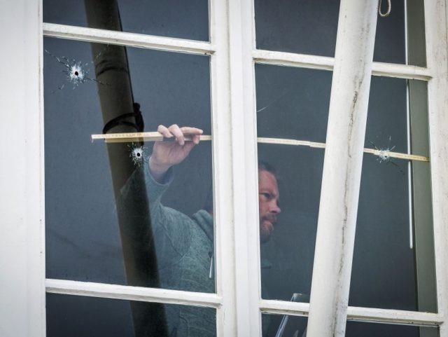 A technician takes measures of a window with bullet holes at the Embassy of Saudi Arabia i