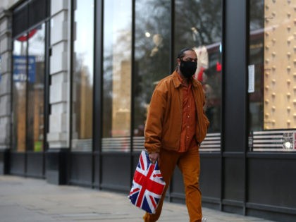 LONDON, ENGLAND - DECEMBER 12: A shopper wearing a face mask carries a Union Jack shopping bag along Oxford Street on December 12, 2020 in London, England. (Photo by Hollie Adams/Getty Images)