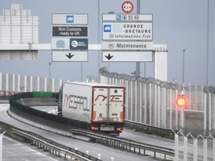 Trucks depart for England via the Channel Tunnel at the port of Calais on December 25, 2020. - Rail and sea links between the UK and France will remain open over Christmas to clear the backlog of thousands of trucks stranded by border closures due to the discovery of a …