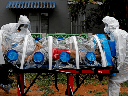 City of Tshwane's Special Infection Unit paramedics push a man inside an ambulance showing symptoms of COVID-19 coronavirus in the isolation chamber equipped with a negative pressure filtration system from his home in the north of Pretoria, South Africa, on January 15, 2021. (Photo by Phill Magakoe / AFP) (Photo …