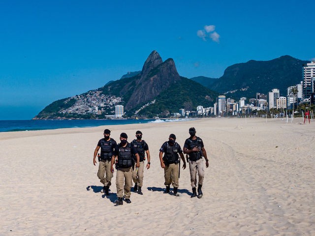 RIO DE JANEIRO, BRAZIL - MARCH 21: An aerial view of police officers patrolling Ipanema beach during the closing of the beaches according to a municipal decree to curb the spread of COVID-19 on March 21, 2021 in Rio de Janeiro, Brazil. As the second wave of COVID-19 hits Brazil, cases in the State of Rio de Janeiro have increased in recent weeks. The state capital, the city of Rio de Janeiro, has closed access to all its beaches since Saturday. On the other hand, other cities in the same state remain open. Since the start of the pandemic, the Marvelous City has reported over 20,000 deaths. Brazil is in a critical situation due to the emergence of new variants and a potential collapse of its health system. (Photo by Buda Mendes/Getty Images)