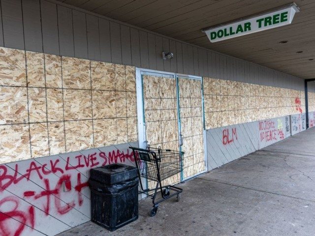 A shopping mall that had it's store front windows broken and was looted during the previous night's unrest is boarded up near the Brooklyn Center police station in Brooklyn Center, Minnesota on April 14, 2021. - Minneapolis has been roiled by nights of violent protests after police officer Kim Potter, …