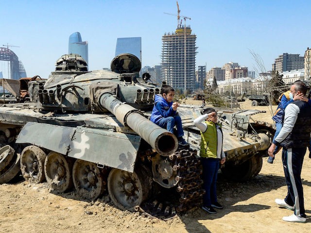 A boy salutes in front of a tank while visiting the Military Trophy Park that showcases military equipment seized from Armenian troops during the last year war over the disputed Nagorno-Karabakh region, in Baku on April 15, 2021. (Photo by Tofik BABAYEV / AFP) (Photo by TOFIK BABAYEV/AFP via Getty Images)