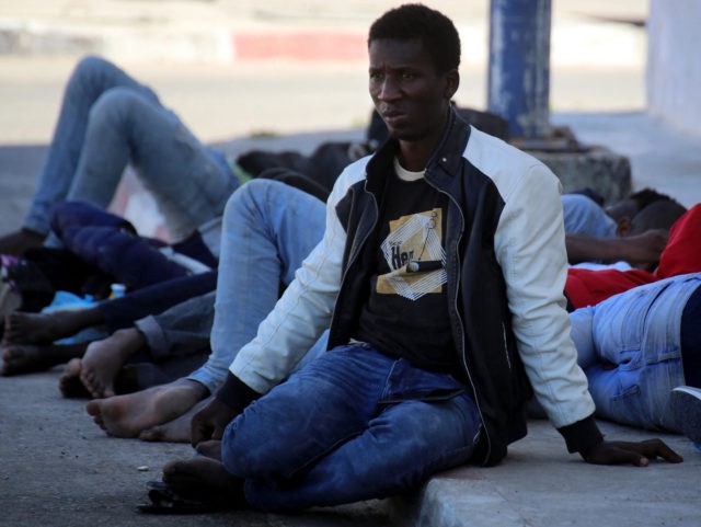 African migrants who were rescued by the Tunisian army as they attempted to cross the Mediterranean Sea by boat, rest at the port of El Ketef in Ben Guerdane, in southern Tunisia near the border with Libya, on June 11, 2021. - Tunisia and Libya are key departure points for …