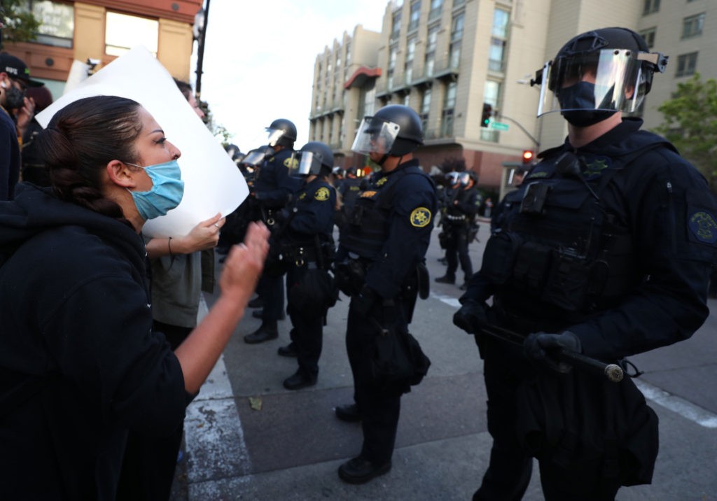 OAKLAND, CALIFORNIA - MAY 29: A women a conveys her message to police during a protest sparked by the death of George Floyd while in police custody on May 29, 2020 in Oakland, California. Earlier today, former Minneapolis police officer Derek Chauvin was taken into custody for Floyd's death. Chauvin has been accused of kneeling on Floyd's neck as he pleaded with him about not being able to breathe. Floyd was pronounced dead a short while later. Chauvin and 3 other officers, who were involved in the arrest, were fired from the police department after a video of the arrest was circulated. (Photo by Justin Sullivan/Getty Images)