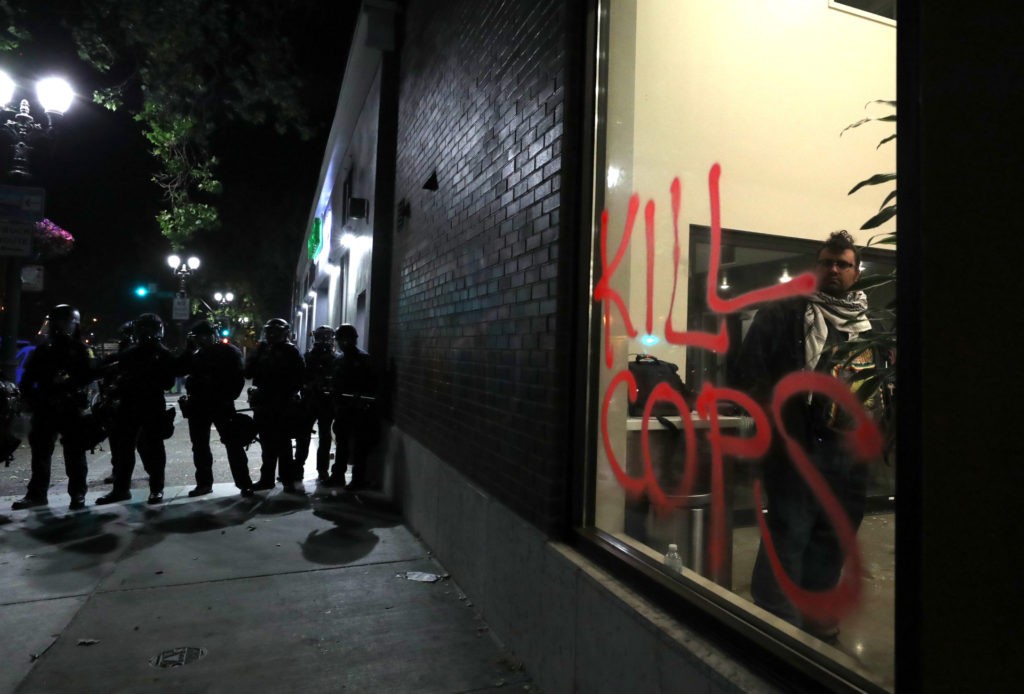 OAKLAND, CALIFORNIA - MAY 29: Police officers stand in line during a protest sparked by the death of George Floyd while in police custody on May 29, 2020 in Oakland, California. Earlier today, former Minneapolis police officer Derek Chauvin was taken into custody for Floyd's death. Chauvin has been accused of kneeling on Floyd's neck as he pleaded with him about not being able to breathe. Floyd was pronounced dead a short while later. Chauvin and 3 other officers, who were involved in the arrest, were fired from the police department after a video of the arrest was circulated. (Photo by Justin Sullivan/Getty Images)