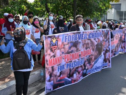 Gathered supporters of boxing icon Manny Pacquiao hold a banner as Pacquiao files his cand