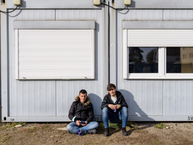Refugees pose for a photo on the grounds of the arrival centre of the initial reception facility of the eastern German state of Brandenburg in Eisenhuettenstadt, on October 25, 2021. - A recent surge in people crossing illegally over the EU's eastern frontier with Belarus has placed major strains on …