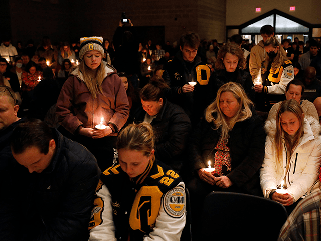 Oxford High students stand holding candles during a vigil after a shooting at Oxford High School at Lake Pointe Community Church in Lake Orion, Michigan on November 30, 2021. - A 15-year-old student opened fire at his Michigan high school on November 30, killing three teenagers and wounding eight other …