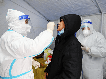This photo taken on November 29, 2021 shows a resident undergoing a nucleic acid test for the Covid-19 coronavirus in Manzhouli in China's northern Inner Mongolia region. - China OUT (Photo by CNS / AFP) / China OUT (Photo by STR/CNS/AFP via Getty Images)