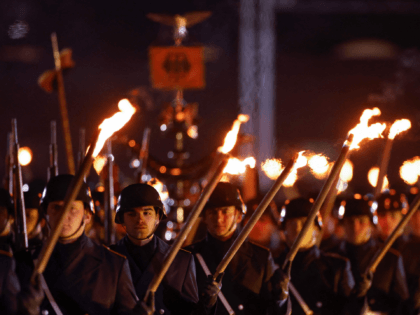 Members of the German armed forces carry torches as they march at the Defence Ministry during the Grand Tattoo (Grosser Zapfenstreich), a ceremonial send-off for outgoing German Chancellor Angela Merkel in Berlin on December 2, 2021. (Photo by Odd ANDERSEN / POOL / AFP) (Photo by ODD ANDERSEN/POOL/AFP via Getty …