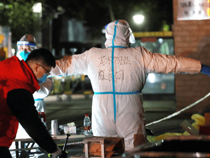 This photo taken on December 2, 2021 shows a staff member spraying disinfectant on his colleague in personal protective equipment (PPE) at a residental area which is restricted due to the spread of Covid-19 in Shanghai. - China OUT (Photo by AFP) / China OUT (Photo by STR/AFP via Getty …