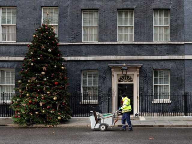 A City of Westminster worker cleans the street in front of 10 Downing Street, the official