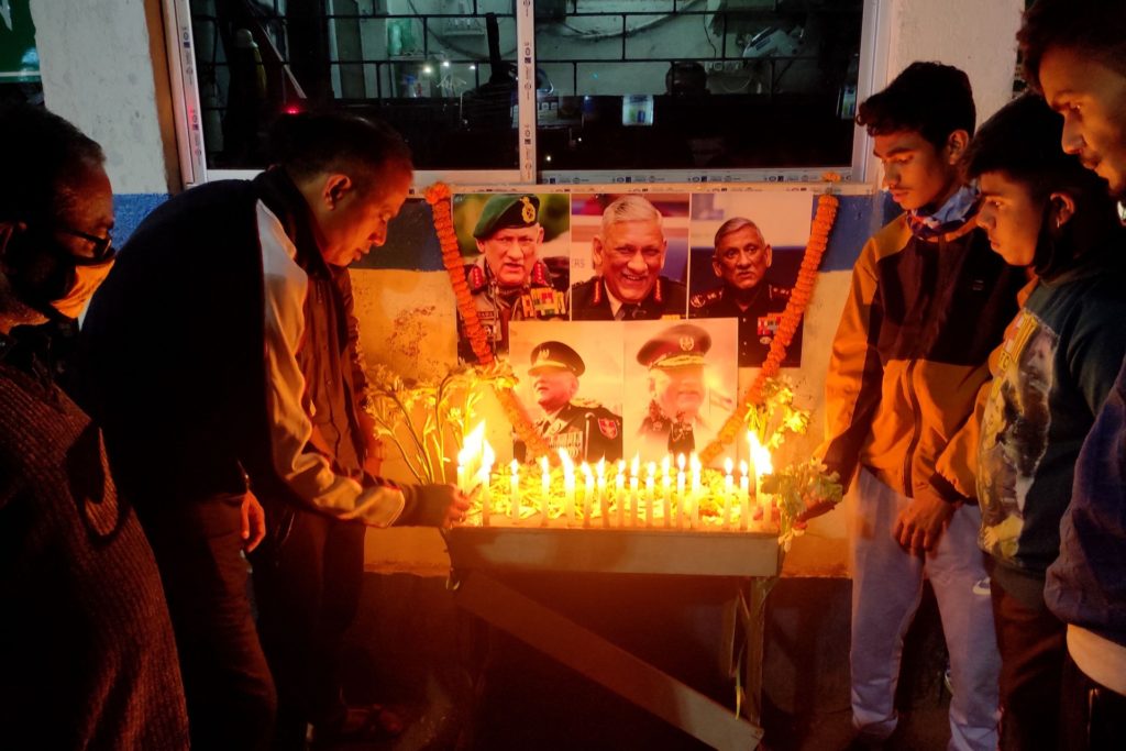 People light candles to pay their respect in front of a portrait of defence chief General Bipin Rawat in Siliguri on December 8, 2021 after reports of a helicopter crash in which defence chief General Bipin Rawat and his wife were among 13 casualties. (Photo by Diptendu DUTTA / AFP) (Photo by DIPTENDU DUTTA/AFP via Getty Images)
