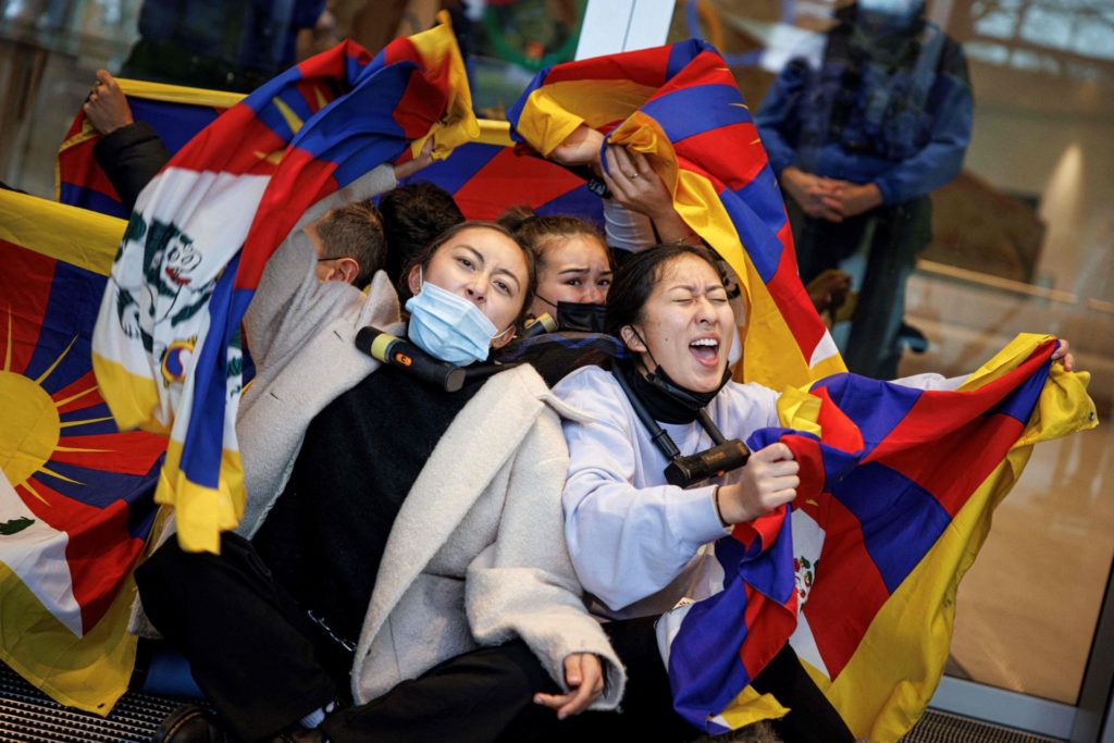 Tibetan activists from the Students for a Free Tibet association, as they perform a sit in at the entrance of the International Olympic Committee (IOC) headquarters ahead of the February's Beijing 2022 Winter Olympics, on December 11, 2021 in Lausanne. - Human rights campaigners and exiles accuses Beijing of religious repression and massively curtailing rights in Tibet. (Photo by VALENTIN FLAURAUD / AFP) (Photo by VALENTIN FLAURAUD/AFP via Getty Images)