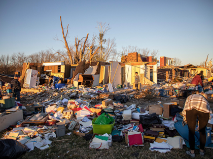 Kitty Williams's (R) gathers belongings of what is left of her house after extreme weather hit the area, in Bowling Green, Kentucky on December 13, 2021. - Kentucky officials voiced relief Monday that dozens of workers at a candle factory appear to have survived tornadoes that killed at least 88 …