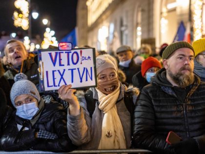 A woman holds a placard reading 'Veto - Lex TVN' as she takes part in a demonstration against a new rule voted in Polish parliament pointed against freedom of media and TVN - opposition to government tv station especialy, in Warsaw, Poland on December 19, 2021. - Thousands of people …