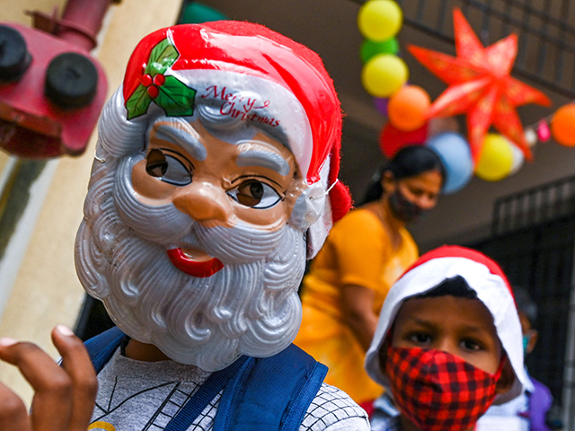 A boy wearing a Santa Clause mask arrives to join the Christmas celebration at their school in Chennai on December 23, 2021. (Photo by Arun SANKAR / AFP) (Photo by ARUN SANKAR/AFP via Getty Images)